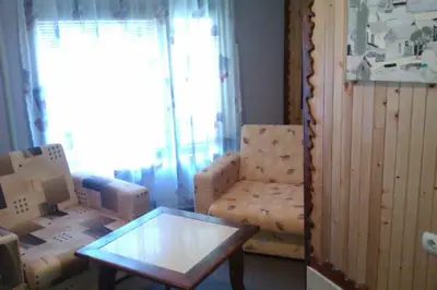 a living room with a chair and a glass table at Семеен хотел Калина Family hotel Kalina Говедарци in Govedartsi