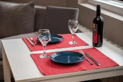 a table with two plates and a bottle of wine at All Seasons Apartments Iglika 2 in Borovets