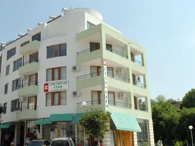 a tall white building with a sign in front of it at Family Hotel Bistritsa in Sandanski