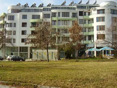 a large apartment building with a park in front of it at Family Hotel Bistritsa in Sandanski