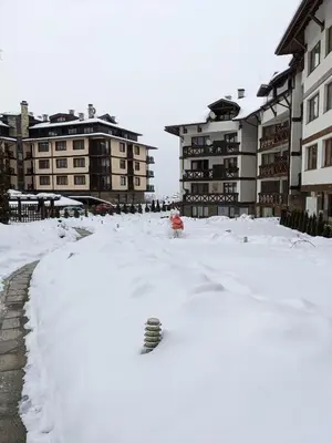 a pile of snow in front of some buildings at Casual Apartment near Gondola & City Center - Neon in Bansko