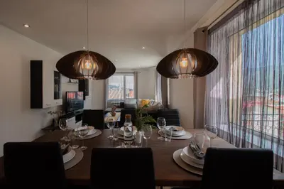 a dining room with a table with plates and glasses at Hyggemate - 2 Bed Room Warm Stay in Sarnitsa in Sarnitsa