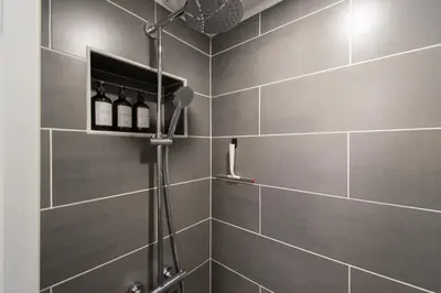 a bathroom with a shower with wine bottles on a wall at Hyggemate - 2 Bed Room Warm Stay in Sarnitsa in Sarnitsa