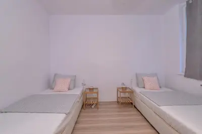 two beds in a room with two chairs at Atacama - spacious apartment in Lozenets area by Flat Mаnager by Flat Mаnager in Sofia