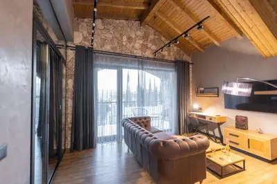 a living room with a couch and a large window at Villa Sintica in Sandanski