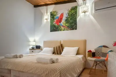 a bedroom with a bed with a bird painting on the wall at The White House Sofia in Sofia