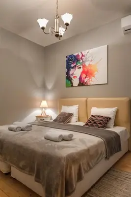 a bedroom with a large bed and a chandelier at The White House Sofia in Sofia