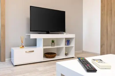 a white entertainment center with a flat screen tv on it at Apartment Valerie walking distance to Top Center in Plovdiv