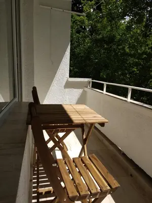 a wooden table and a chair sitting on a balcony at Dolce Vita-Sofia Apartment in Sofia