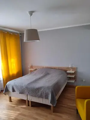 a bedroom with a bed and a yellow chair at Dolce Vita-Sofia Apartment in Sofia