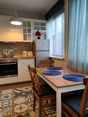 a kitchen with a table and chairs and a refrigerator at Dolce Vita-Sofia Apartment in Sofia