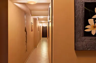a hallway with orange walls and a tile floor at Family Hotel Marsina in Sofia