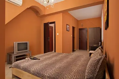 a bedroom with a bed and a tv at Family Hotel Marsina in Sofia