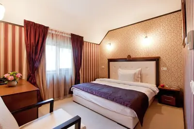 a hotel room with a large bed and a table at Best Western Plus Bristol Hotel in Sofia