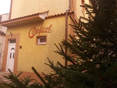a sign on the side of a building with a christmas tree at Comfort Guest House in Samokov