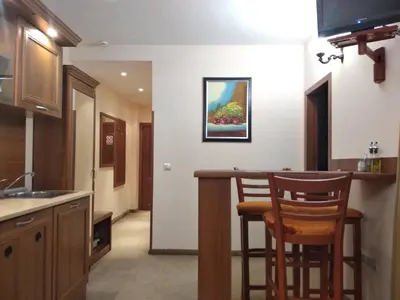 a kitchen with a bar with two chairs in it at private apartments Emerald in Bansko