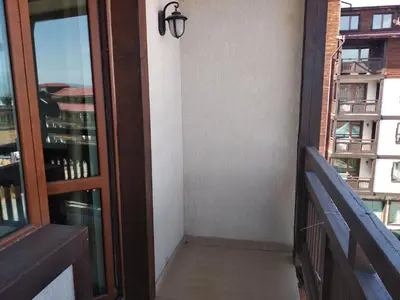 a room with a balcony with a door and a window at private apartments Emerald in Bansko