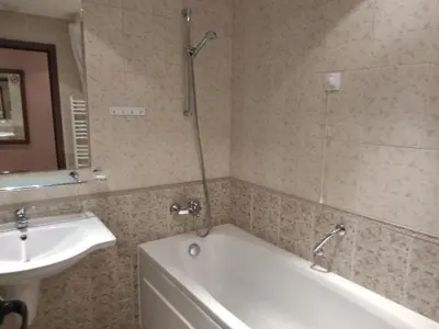 a bathroom with a bath tub and a sink at private apartments Emerald in Bansko