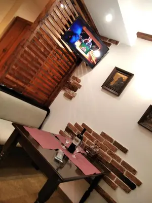 a living room with a table and a television on a wall at private apartments Emerald in Bansko