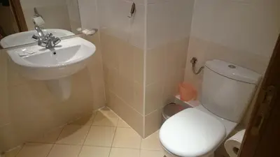 a bathroom with a white toilet and a sink at Studio Villa Park 119 in Borovets