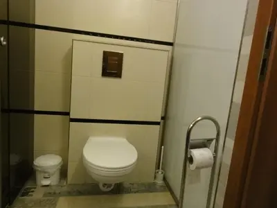a small bathroom with a toilet and a toilet paper dispenser at Apartment Sofia Center 2 in Sofia