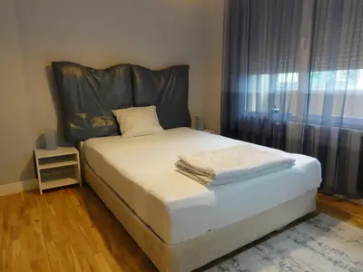 a bed with a leather headboard in a bedroom at Apartment Sofia Center 2 in Sofia