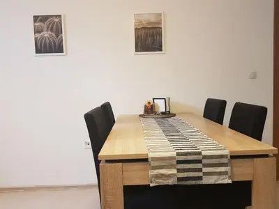 a dining room table with chairs and a blanket on it at Radomir Downtown Apartments in Radomir