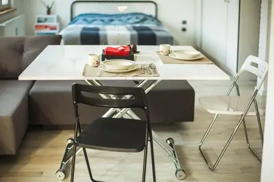 a table and chairs in a room with a bed at Sunny studio on ulica Lyuben Karavelov in Sofia