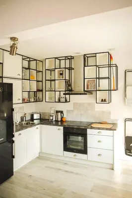 a kitchen with white cabinets and black appliances at Sunny studio on ulica Lyuben Karavelov in Sofia