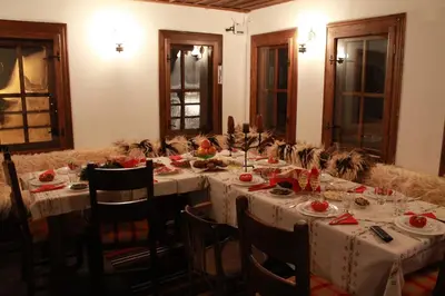 a dining room with a long table with white table cloth at Къща за гости Гайтана in Shiroka Lŭka