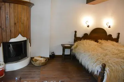 a living room with a bed with a large tufted bed sidx sidx sidx at Къща за гости Гайтана in Shiroka Lŭka
