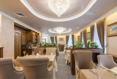 a restaurant with tables and chairs and a chandelier at Residence City Garden - Certificate of Excellence Top 10 BEST Five-Stars City Hotels for 2024 awarded by HTIF in Plovdiv
