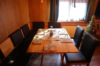a dining room with a wooden table and chairs at Roots Apartment in Borovets