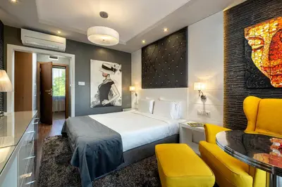 a hotel room with a bed and a yellow chair at Family Hotel Strannopriemnitza in Oreshak