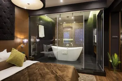 a bathroom with a tub and a large glass shower at Family Hotel Strannopriemnitza in Oreshak
