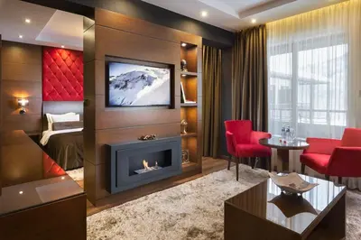 a hotel room with a fireplace and a bedroom at Family Hotel Strannopriemnitza in Oreshak