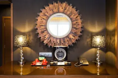 a mirror above a table with a phone and two lamps at Family Hotel Strannopriemnitza in Oreshak