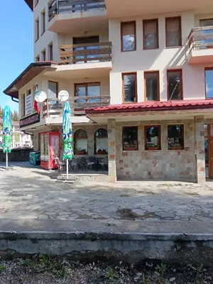 a building with umbrellas in front of a building at Пампорово апартамент,студио Милка 17,в х Росица, за ски и туризъм,целогодишно in Pamporovo