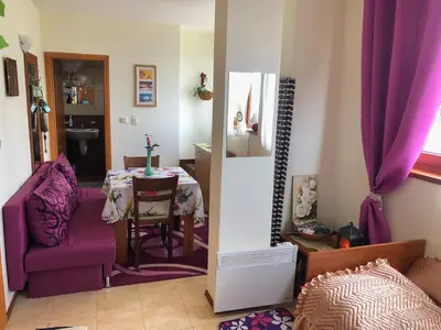 a living room with a table and a purple chair at Пампорово апартамент,студио Милка 17,в х Росица, за ски и туризъм,целогодишно in Pamporovo