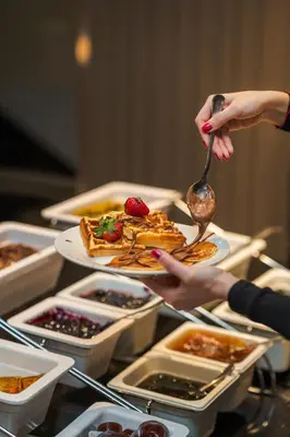 a group of people holding plates of food on a table at Medite Spa Resort and Villas in Sandanski