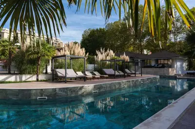 a swimming pool with chairs and a gazebo at Medite Spa Resort and Villas in Sandanski