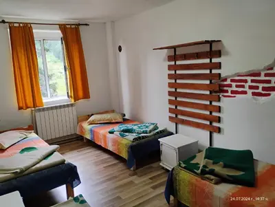 a living room with two beds and a staircase at хижа 