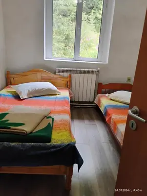 a bedroom with two beds and a window at хижа 