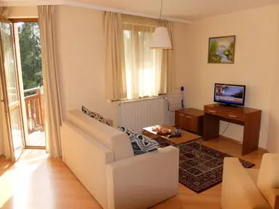 a living room with a white couch and a television at Borovets Apartment, Villa Park in Borovets