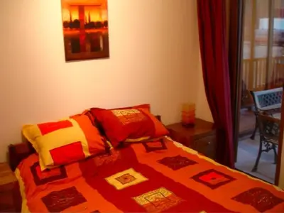 a bedroom with a bed with a quilt on it at MD Alexander Services Apartments in Bansko