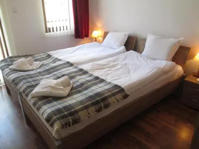 a large bed with two white towels on it at MD Alexander Services Apartments in Bansko