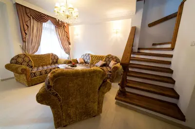 a person sitting on a couch in a living room at Ikonomov House in Bansko