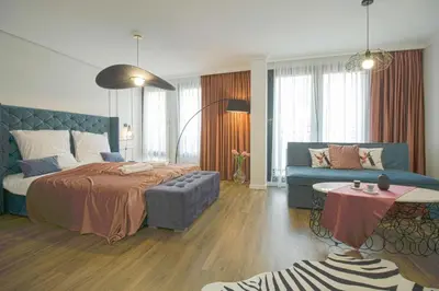 a bedroom with a large bed and a couch at Boutique Apartments Blagoevgrad in Blagoevgrad