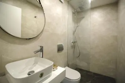 a bathroom with a sink and a mirror and a toilet at Boutique Apartments Blagoevgrad in Blagoevgrad
