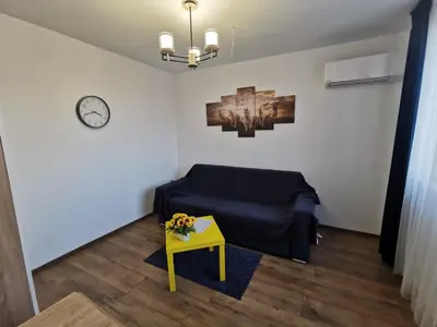 a living room with a blue couch and a table at Studio Oslo byPMM in Plovdiv